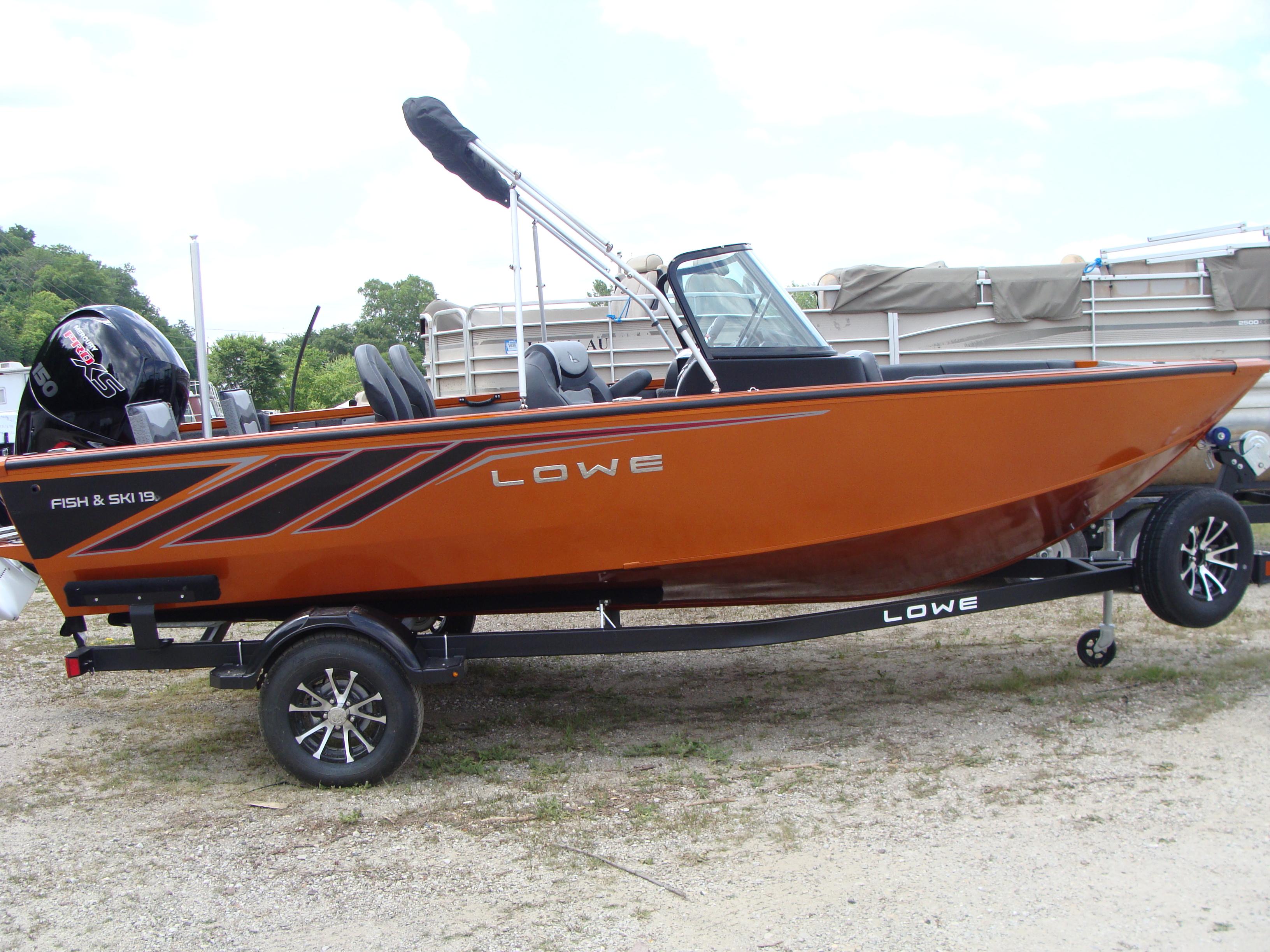 Slide: The Image of 2023 Lowe FS 1900 boat on trailer, orange exterior, Fish & Ski model. - 1