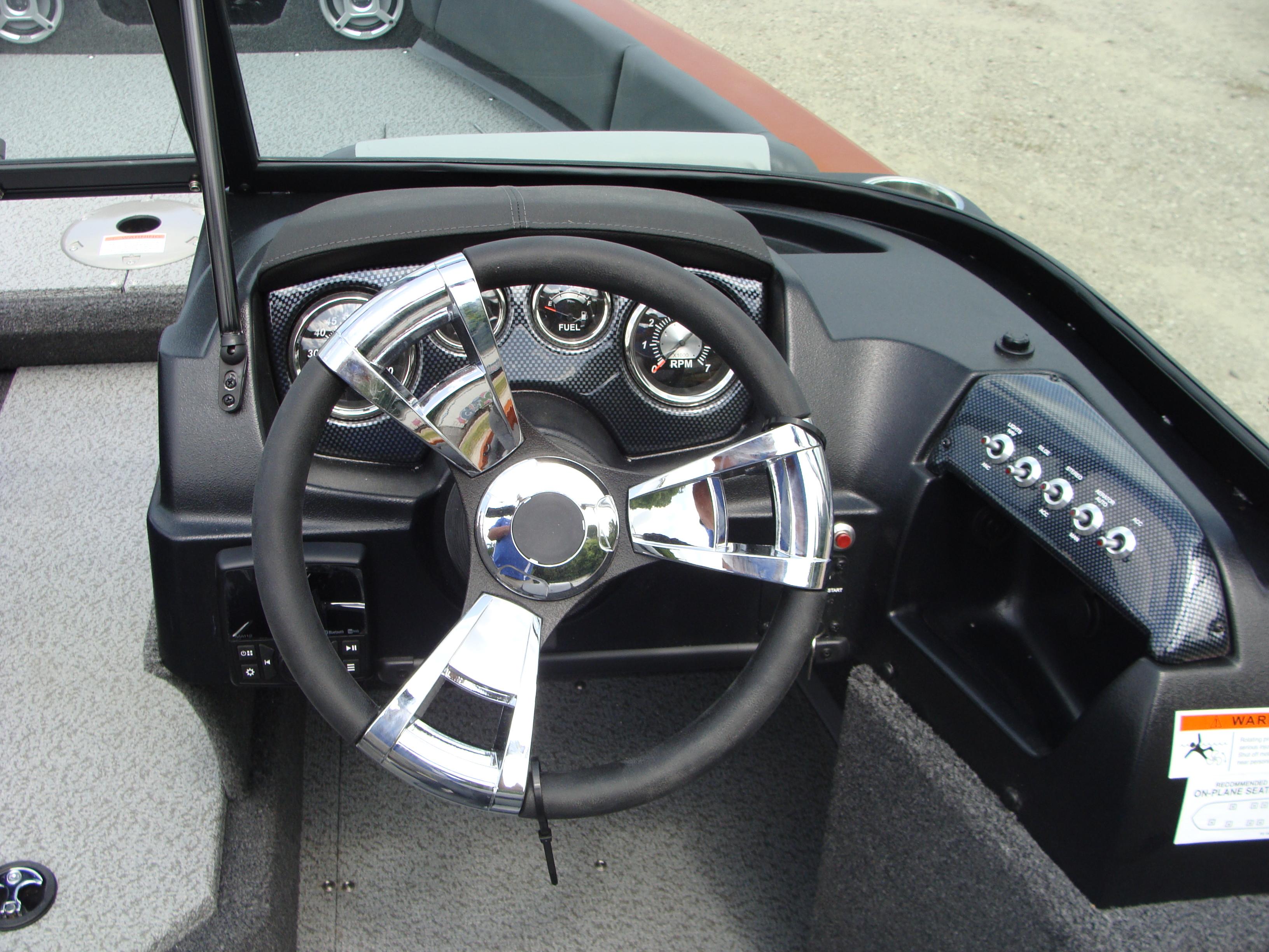 Slide: The Image of 2023 Lowe FS 1900 boat dashboard with steering wheel and instrument panel. - 9