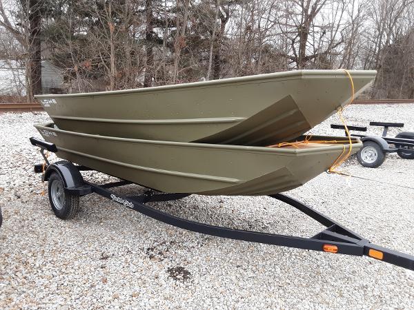 Slide: The Image of 2024 Lowe Jon L1448 boats stacked on a trailer in a gravel lot. - 0