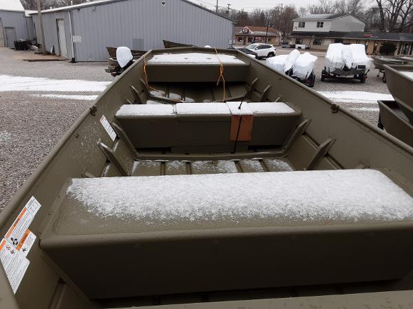 Slide: The Image of 2024 Lowe Jon L1448 boat with light snow on seats, parked outdoors. - 3