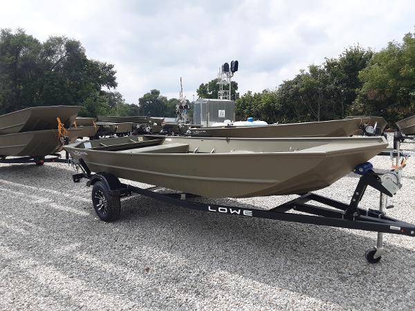 Slide: The Image of 2024 Lowe Jon L1648M boat on a trailer in a gravel lot. - 0