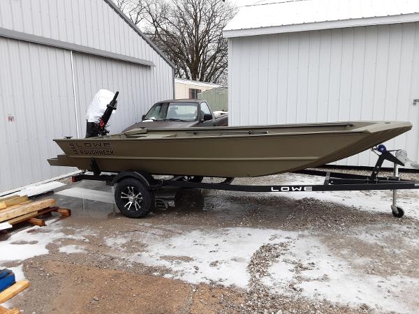 Slide: The Image of 2024 Lowe Roughneck 1660 boat on trailer, parked outside near white buildings. - 0