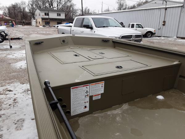 Slide: The Image of 2024 Lowe Roughneck 1660 boat with storage compartments, parked outdoors in a snowy area. - 2