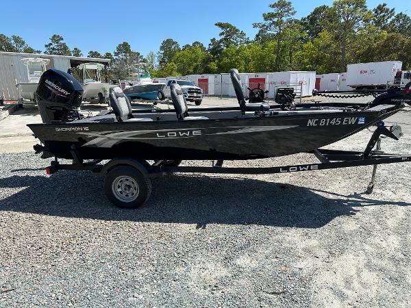 Slide: The Image of 2022 Lowe Skorpion 16 fishing boat on a trailer in a parking lot. - 7