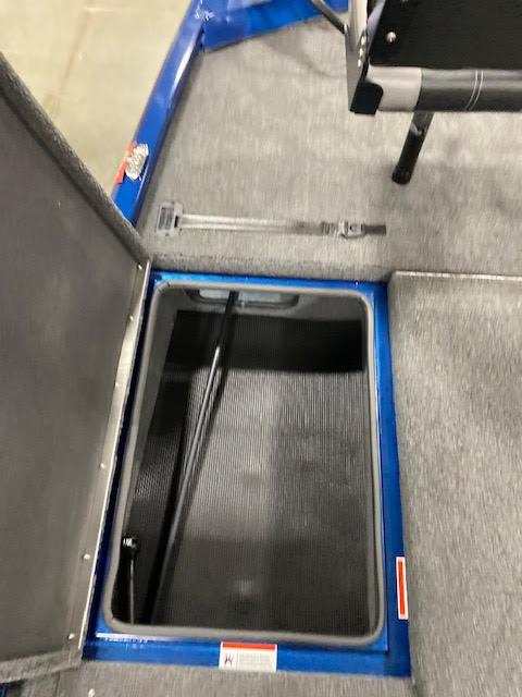 Slide: The Image of 2023 Lowe Stinger 188 Pro Series boat storage compartment with open hatch, gray carpet interior. - 7