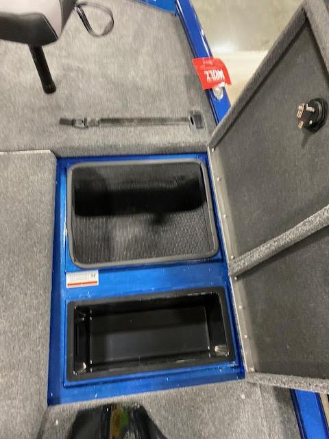 Slide: The Image of 2023 Lowe Stinger 188 Pro Series boat storage compartments, open and empty, with gray carpeted interior. - 9