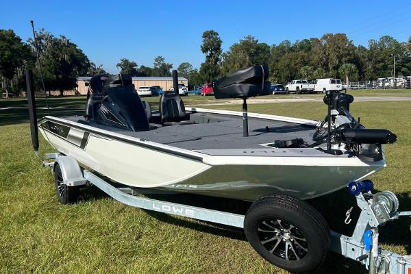 Slide: The Image of 2024 Lowe Stinger 188 SC fishing boat on a trailer in a grassy area. - 1