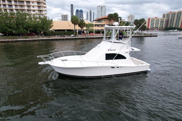 Slide: The Image of 1993 Luhrs 320 Tournament boat on water, cityscape background. - 1