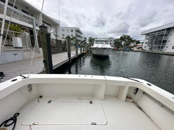 Slide: The Image of 1993 Luhrs 320 Tournament boat docked in a marina with surrounding buildings. - 13
