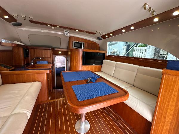 Slide: The Image of 1993 Luhrs 320 Tournament yacht interior with wood finish, seating, and dining area. - 18