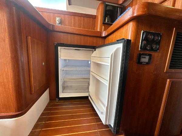 Slide: The Image of 1993 Luhrs 320 Tournament interior with open fridge and wooden cabinetry. - 20