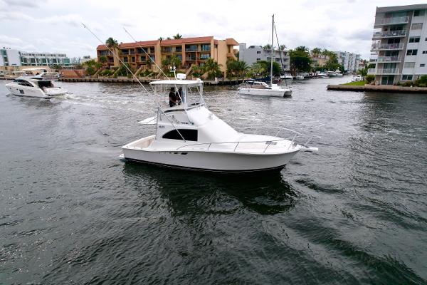 Slide: The Image of 1993 Luhrs 320 Tournament boat cruising in a marina with other vessels nearby. - 3