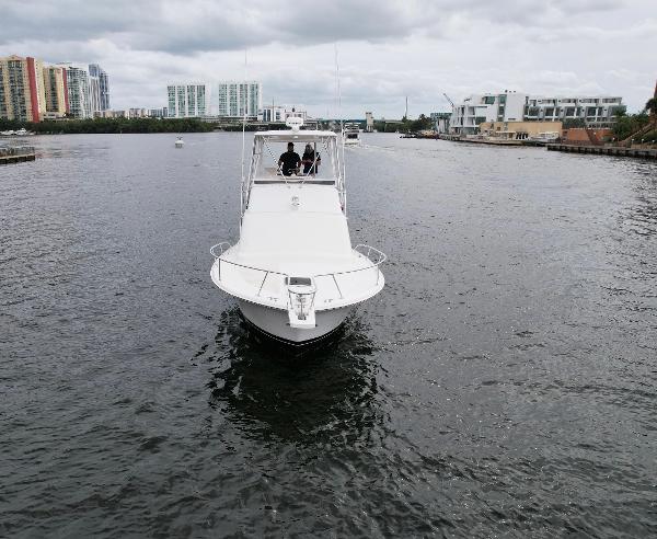 Slide: The Image of 1993 Luhrs 320 Tournament boat cruising on a river with cityscape background. - 4