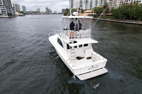 Slide: The Image of 1993 Luhrs 320 Tournament boat cruising in a city waterway, surrounded by buildings. - 5