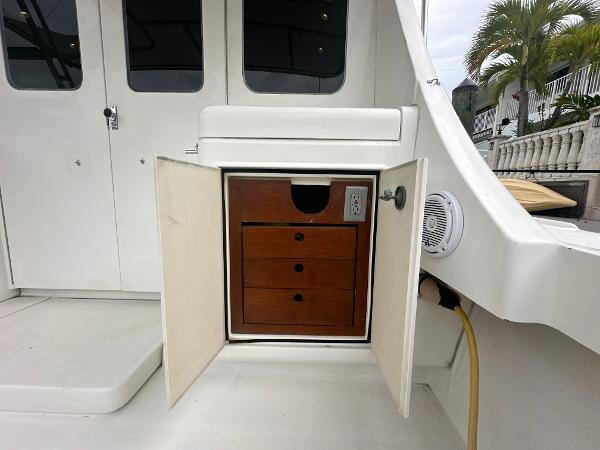 Slide: The Image of 1993 Luhrs 320 Tournament boat interior with open cabinet and wooden drawers. - 9
