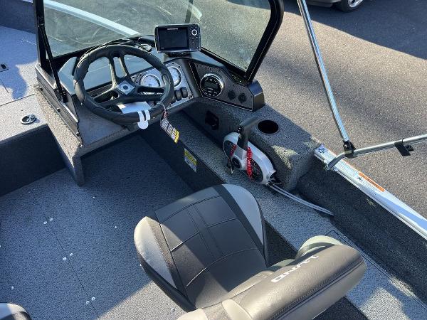 Slide: The Image of 2024 Lund 1650 Angler Sport boat cockpit with steering wheel and control panel. - 5