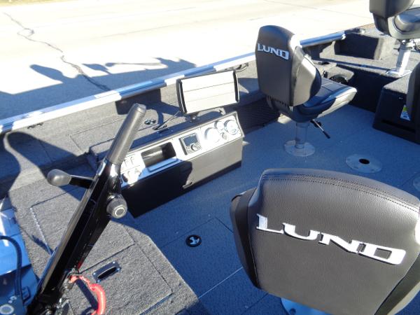 Slide: The Image of 2024 Lund 1875 Pro Guide boat interior with steering console and branded seats. - 14
