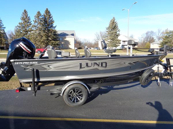 Slide: The Image of 2024 Lund 1875 Pro Guide fishing boat on trailer in residential area. - 2