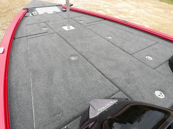 Slide: The Image of 2024 Lund 2075 Pro-V Bass XS boat deck with gray carpeting and red trim. - 11