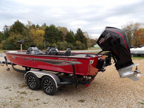 Slide: The Image of 2024 Lund 2075 Pro-V Bass XS boat in red with trailer and outboard motor. - 5