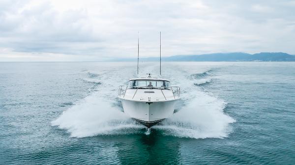 Slide: The Image of 2023 Mag Bay 42 Express cruising on open water, creating a dynamic wake. - 11