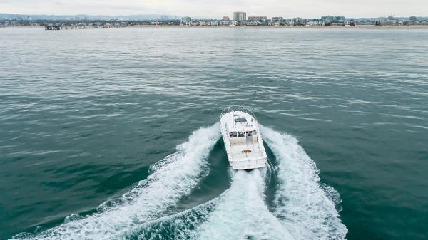 Slide: The Image of 2023 Mag Bay 42 Express cruising on open water near a coastal city. - 13