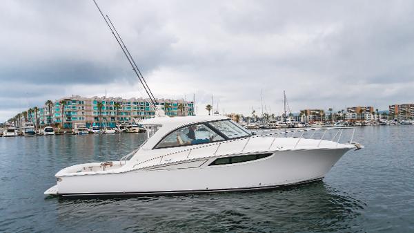Slide: The Image of 2023 Mag Bay 42 Express yacht on calm water with marina backdrop. - 15