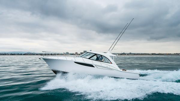 Slide: The Image of 2023 Mag Bay 42 Express cruising on open water under cloudy skies. - 2
