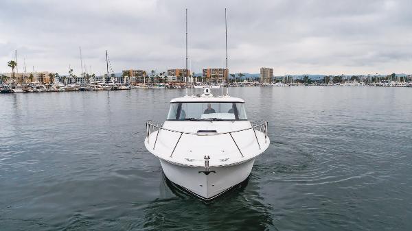 Slide: The Image of 2023 Mag Bay 42 Express yacht on calm water, marina in background. - 24
