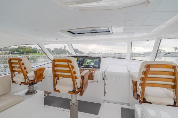 Slide: The Image of 2023 Mag Bay 42 Express yacht interior with helm and seating, featuring elegant wooden chairs. - 33