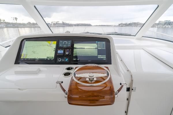 Slide: The Image of Helm of 2023 Mag Bay 42 Express with advanced navigation displays and wooden steering wheel. - 36