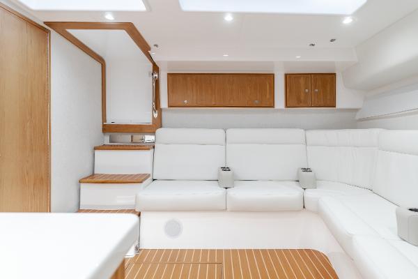 Slide: The Image of 2023 Mag Bay 42 Express interior with white seating and wooden accents. - 47