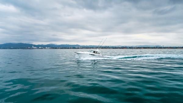 Slide: The Image of 2023 Mag Bay 42 Express cruising on calm ocean under cloudy sky. - 5