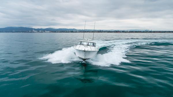 Slide: The Image of 2023 Mag Bay 42 Express cruising on open water under cloudy skies. - 6