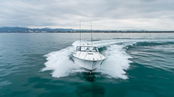 Slide: The Image of 2023 Mag Bay 42 Express cruising on open water, creating a dynamic wake. - 7
