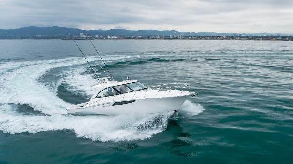 Slide: The Image of 2023 Mag Bay 42 Express cruising on open water with cityscape in background. - 8