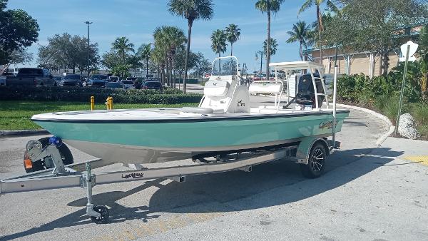 Slide: The Image of 2022 Mako 18 LTS boat on a trailer in a sunny parking lot. - 0