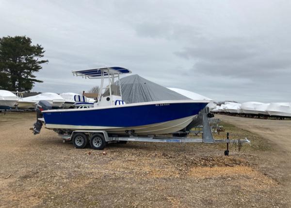Slide: The Image of 1980 Mako 23 boat on trailer, blue and white, parked outdoors. - 0