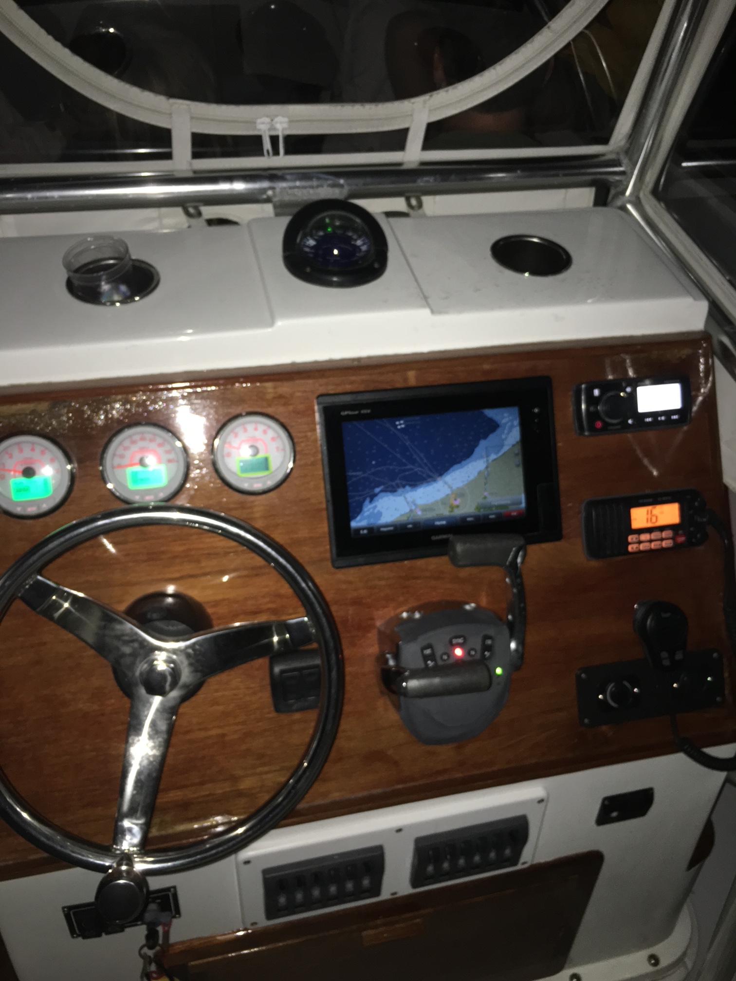 Slide: The Image of 1991 Mako 241 boat dashboard with steering wheel, gauges, GPS, and radio equipment. - 30