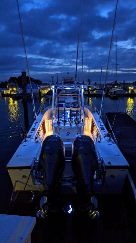 Slide: The Image of 1990 Mako 261 Center Console boat illuminated at night in a marina. - 4