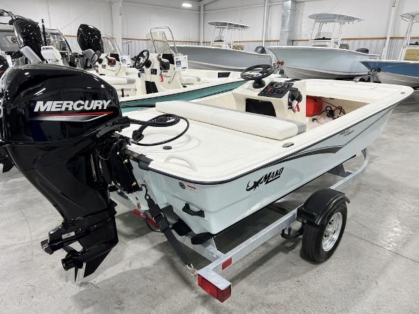 Slide: The Image of 2023 Mako Pro Skiff 13 CC boat with Mercury outboard motor in showroom. - 2