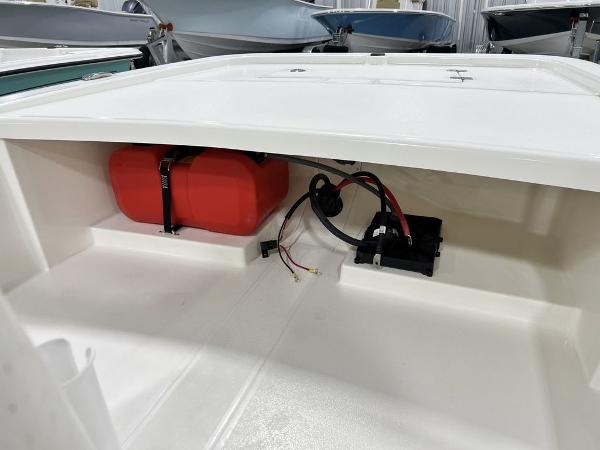Slide: The Image of 2023 Mako Pro Skiff 13 CC storage compartment with red fuel tank and wiring. - 6