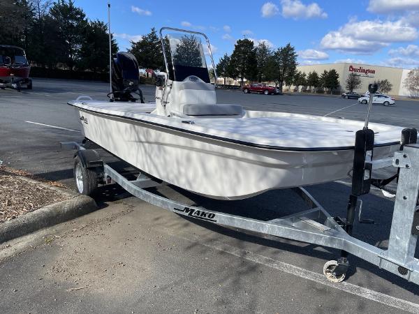 Slide: The Image of 2024 Mako Pro Skiff 13 CC on trailer in parking lot, clear sky background. - 2