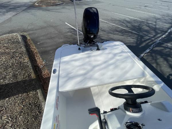 Slide: The Image of 2024 Mako Pro Skiff 13 CC boat in parking lot, featuring steering wheel and outboard motor. - 5