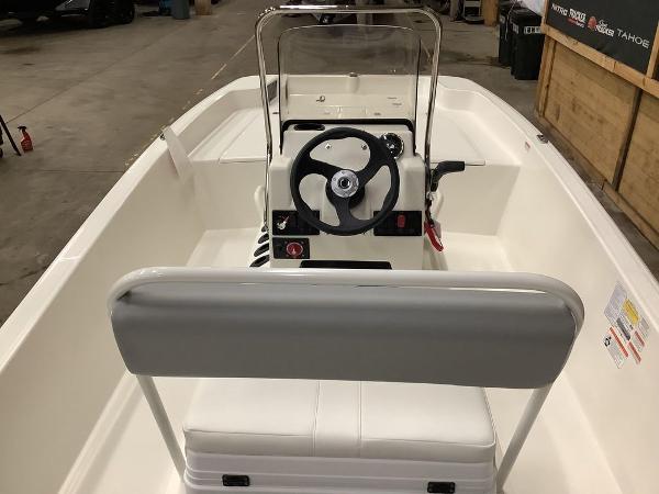 Slide: The Image of 2023 Mako Pro Skiff 17 CC center console boat interior with steering wheel and seating. - 4