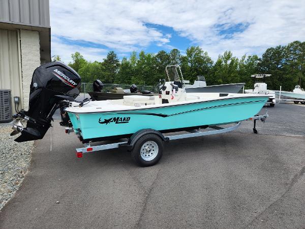 Slide: The Image of 2024 Mako Pro Skiff 17 CC boat on trailer with Mercury outboard motor. - 0