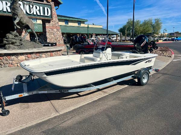 Slide: The Image of 2024 Mako Pro Skiff 17 CC boat on trailer outside a store. - 1
