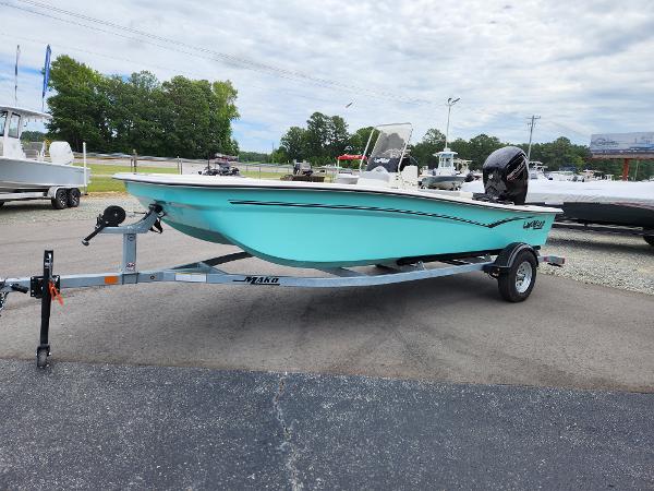 Slide: The Image of 2024 Mako Pro Skiff 17 CC on trailer, light blue hull, outboard motor. - 2