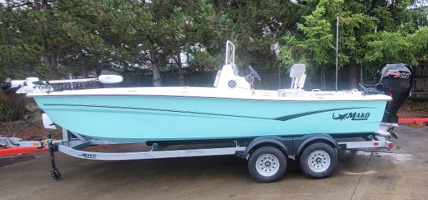 Slide: The Image of 2024 Mako Pro Skiff 19 CC on trailer, side view, light blue hull. - 0