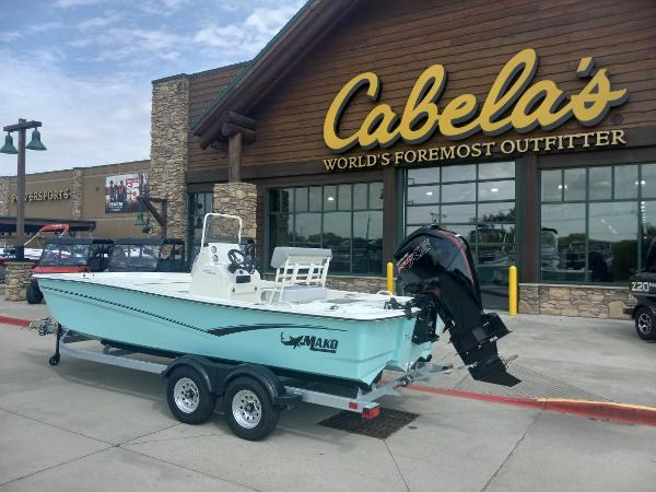 Slide: The Image of 2024 Mako Pro Skiff 19 CC boat on trailer outside Cabela's store. - 1